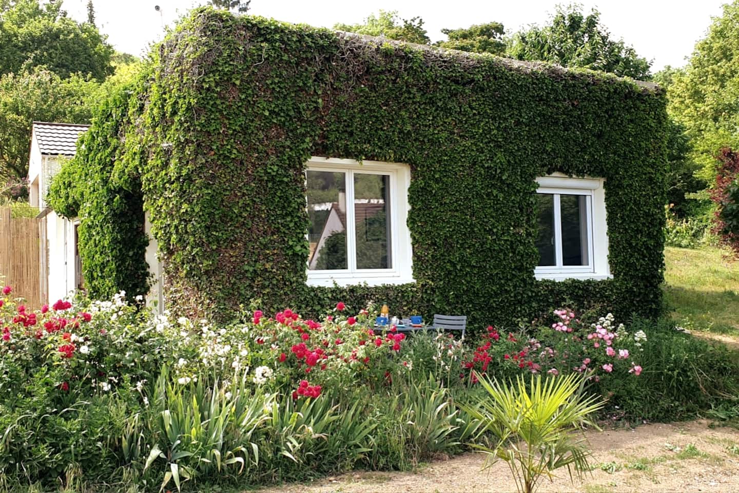 La Maison en Feuilles, sa façade végétalisée et son jardin fleuri